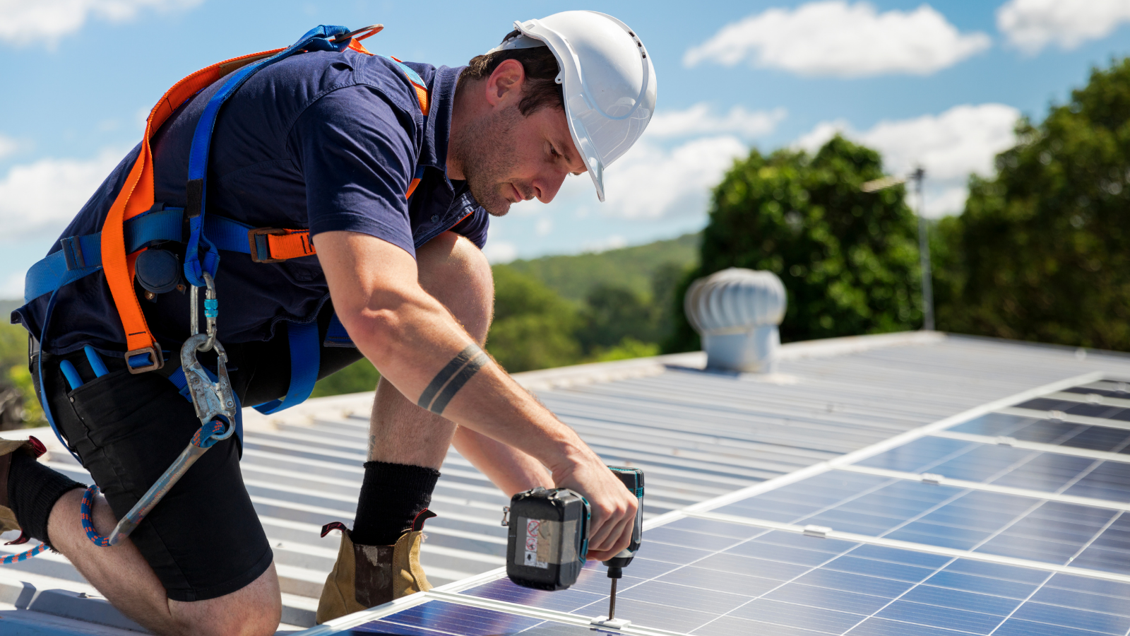 Een installateur die zonnepanelen monteert op een dak